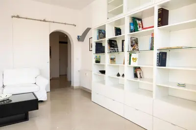 a living room with white bookshelves and a white couch at Roma per te in Rome
