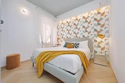 a bedroom with a bed with a yellow blanket on it at YCH-Colorful and classy apartment near Fori Imperiali in Rome