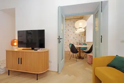 a living room with a television on a wooden cabinet at YCH-Colorful and classy apartment near Fori Imperiali in Rome