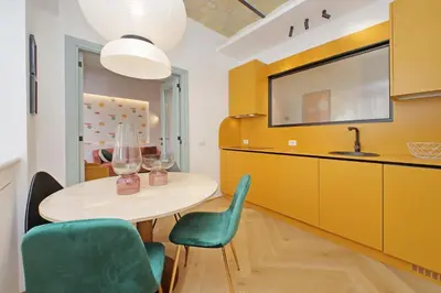 a dining room with a table and green chairs at YCH-Colorful and classy apartment near Fori Imperiali in Rome