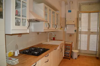 a kitchen with white cabinets and a sink and a stove at Casa Vacanze Zio Gionni in Rome