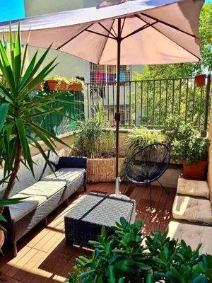 a patio with an umbrella and a couch and table at Vatican Terrace Apartment in Rome