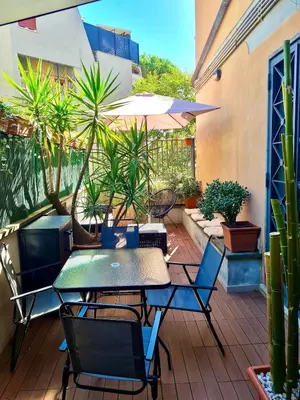 an outdoor patio with tables and chairs and potted plants at Vatican Terrace Apartment in Rome