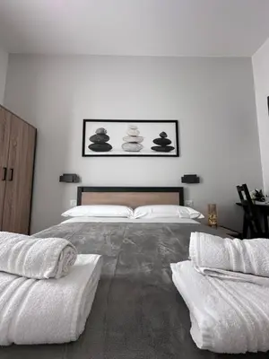 a white bedroom with a large bed with towels on it at ROMA Guesthouse Affittacamere centro citta' SOFTROOMS-Metro' a 1 metro in Rome