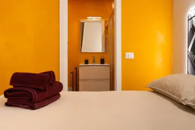 a bedroom with yellow walls and a bed with red towels at Embassy Suites Roma in Rome