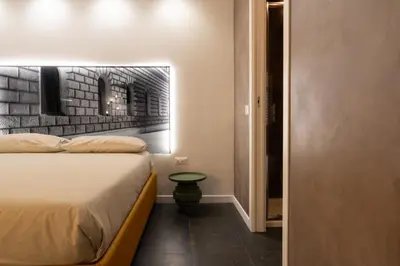 a bedroom with a bed and a brick wall at Embassy Suites Roma in Rome