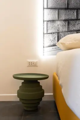 a green table in a room next to a bed at Embassy Suites Roma in Rome