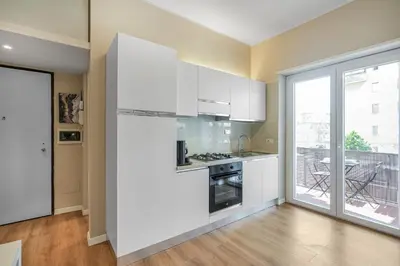 a kitchen with white appliances and a large window at Vatican - Angolo di Roma in Rome