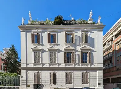 a white building with plants on top of it at Charming apartment in a 1910s building 2 min walk from the Colosseum in Rome