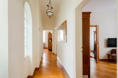 a hallway with white walls and a wooden floor at Charming apartment in a 1910s building 2 min walk from the Colosseum in Rome