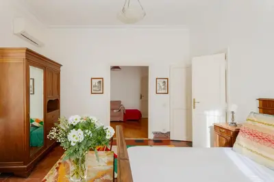 a bedroom with a bed and a vase of flowers at Charming apartment in a 1910s building 2 min walk from the Colosseum in Rome