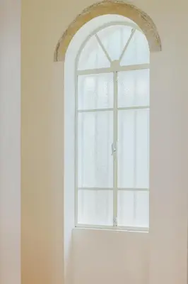 an arched window in a white wall at Charming apartment in a 1910s building 2 min walk from the Colosseum in Rome