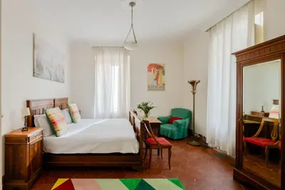 a bedroom with a bed and a desk and a chair at Charming apartment in a 1910s building 2 min walk from the Colosseum in Rome