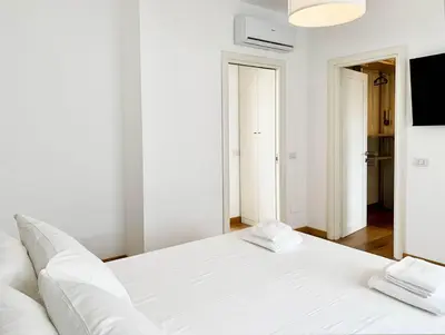 a white bed with two pillows on it in a room at DaliTourism - Vatican Apartment 77 in Rome