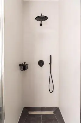 a shower in a white wall with a shower head at Vatican Clodio Suites in Rome