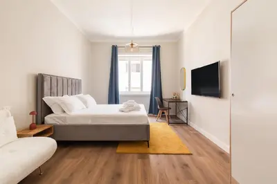 a bedroom with a bed and a desk and a tv at Vatican Clodio Suites in Rome