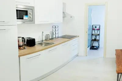 a white kitchen with white cabinets and a sink at Minerva boutique residence 4 in Rome