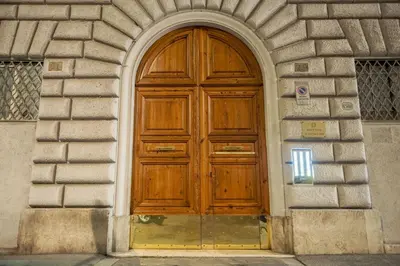 a wooden door in a building with an arch at Minerva boutique residence 4 in Rome