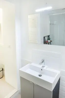 a white bathroom with a sink and a mirror at Minerva boutique residence 4 in Rome