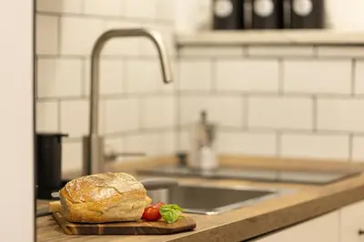 a loaf of bread sitting on a cutting board in a kitchen at Khris Home Apartments - Trastevere Parini in Rome