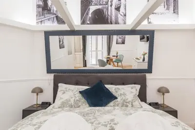 a bedroom with a large mirror above a bed at Scipioni Vatican Studio distante 10 minuti a piedi dal Vaticano in Rome