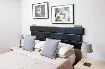 a bedroom with a black and white bed and two lamps at La Lanterna Di San Pietro in Rome