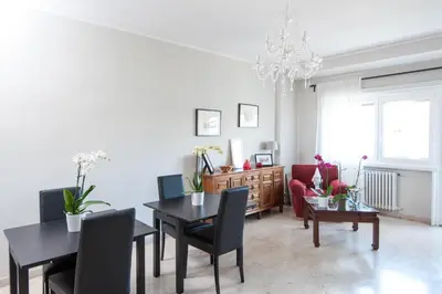 a living room with a table and chairs and a chandelier at La Lanterna Di San Pietro in Rome