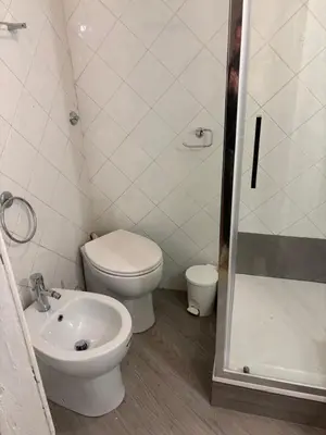 a bathroom with a toilet and a sink and a shower at Liberty House in Rome