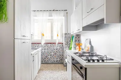 a white kitchen with a stove and a window at Dreamhome61 by Rentbeat in Rome