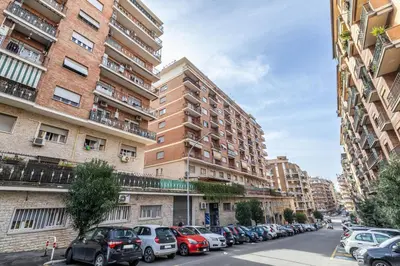 a city street with cars parked in front of tall buildings at Dreamhome61 by Rentbeat in Rome