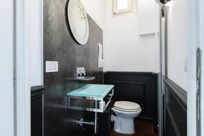 a bathroom with a toilet and a clock on the wall at The Great Beauty in Rome