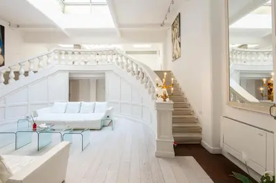 a living room with white furniture and a staircase at The Great Beauty in Rome