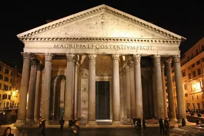 a large building with columns in a city at night at The Great Beauty in Rome