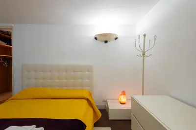 a bedroom with a yellow bed and a lamp at The Great Beauty in Rome