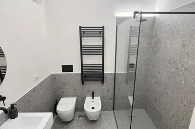 a bathroom with a toilet and a glass shower at Boutique Via Veneto Apartment by SupaStays in Rome