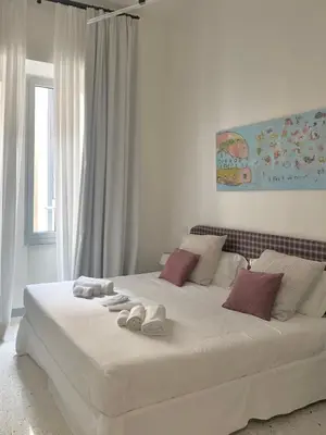 a white bed with towels on it in a bedroom at Boutique Via Veneto Apartment by SupaStays in Rome