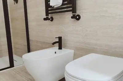 a bathroom with a white toilet and a sink at Boutique Via Veneto Apartment by SupaStays in Rome