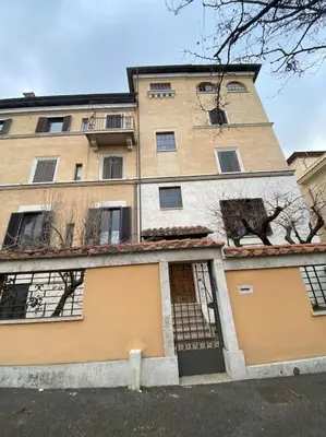 a large apartment building with a gate in front of it at Under Trastevere stars in Rome