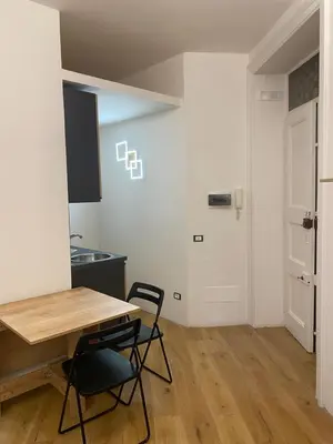 a kitchen with a table and two chairs in a room at Under Trastevere stars in Rome