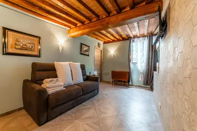 a living room with a brown couch in a room at Appia Antica Country House giardino parcheggio Fermata bus in Rome