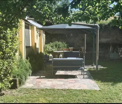a bench under an umbrella in a yard at Appia Antica Country House giardino parcheggio Fermata bus in Rome
