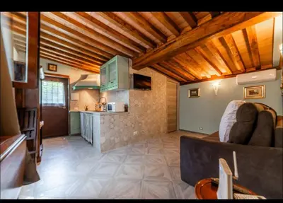 a living room with a couch and a kitchen at Appia Antica Country House giardino parcheggio Fermata bus in Rome