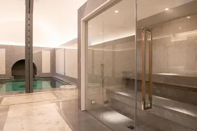 a bathroom with a glass shower and a swimming pool at Palazzo Shedir - The Leading Hotels of the World in Rome