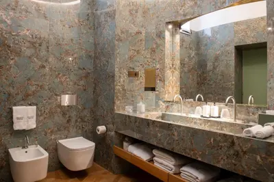 a bathroom with a sink and a toilet and a mirror at Palazzo Shedir - The Leading Hotels of the World in Rome