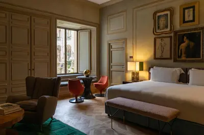 a bedroom with a bed and a chair and a window at Palazzo Shedir - The Leading Hotels of the World in Rome