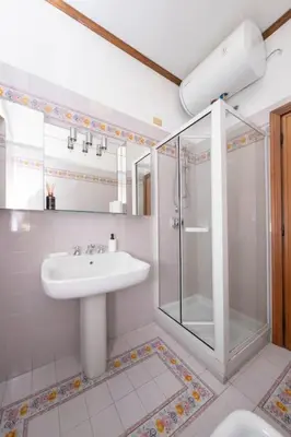 a bathroom with a sink and a glass shower at [10 min Vaticano] Big home Balduina con piscina in Rome