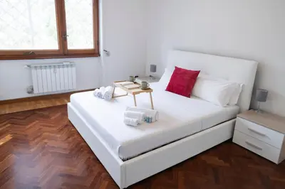 a bedroom with a white bed with red pillows at [10 min Vaticano] Big home Balduina con piscina in Rome