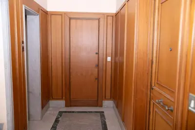 a hallway with wooden doors and a rug at [10 min Vaticano] Big home Balduina con piscina in Rome