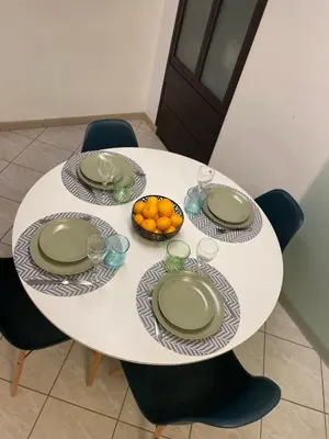 a white table with plates and a bowl of oranges at Boschetto49 in Rome