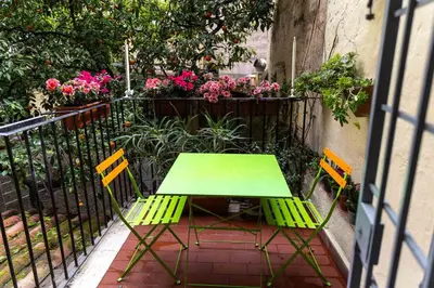 a green table and chairs on a balcony with flowers at Boschetto49 in Rome